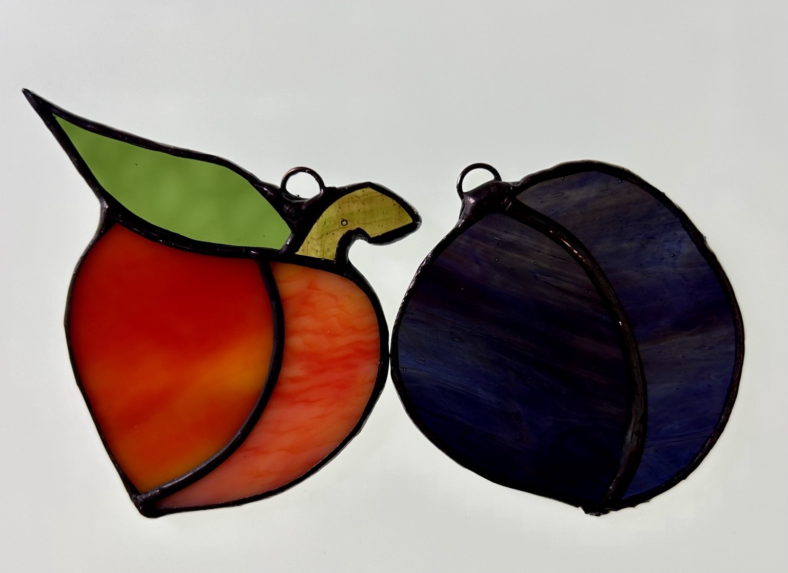 Fruit shapes in warm orange, green and deep purple glass.