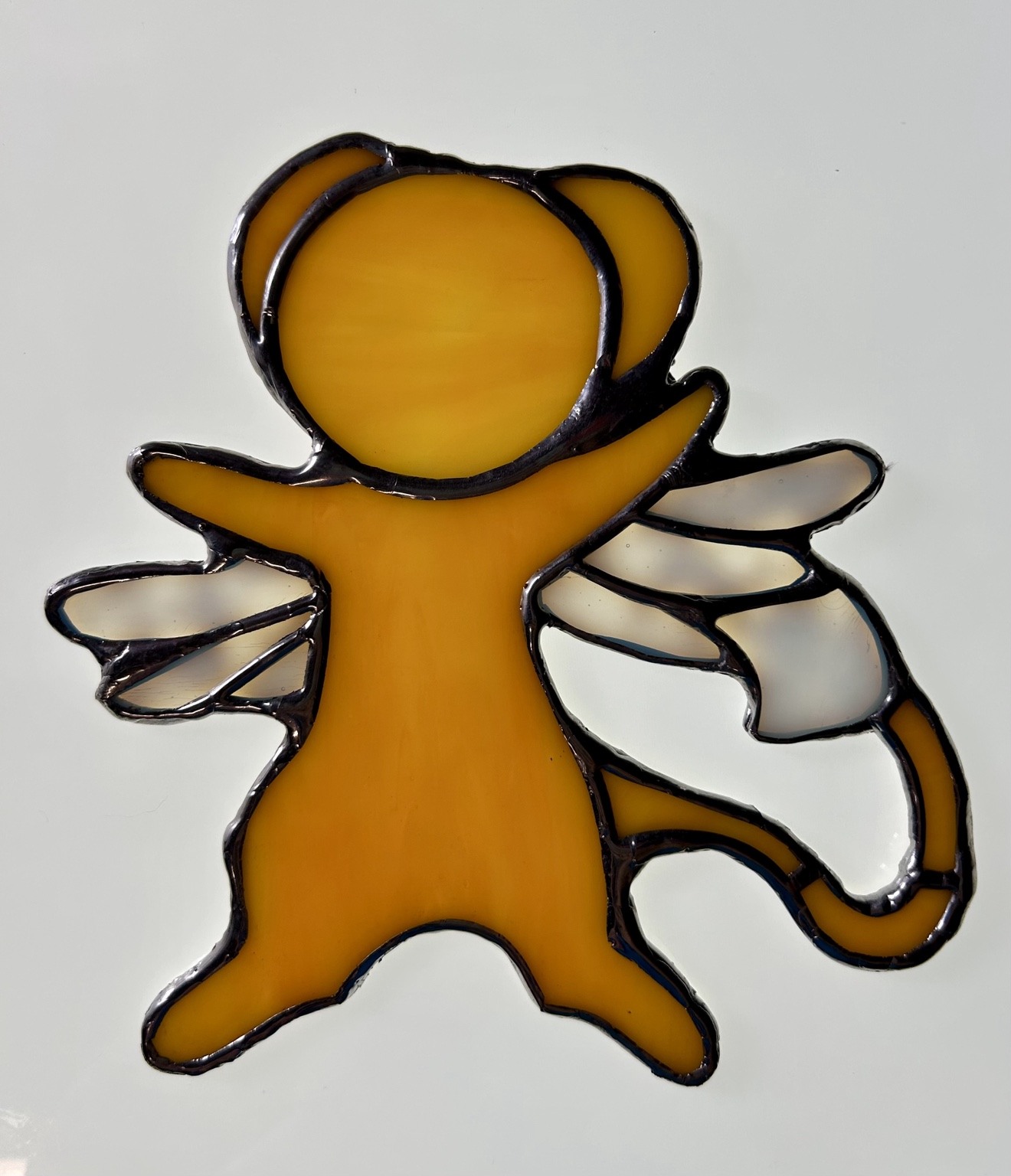 A golden cat silhouette with shimmering wings.