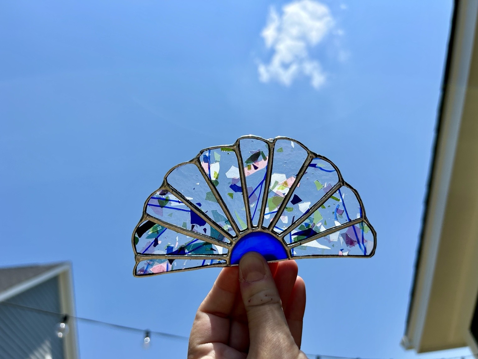 A fan-shaped piece with colorful flecks and a cobalt blue center.