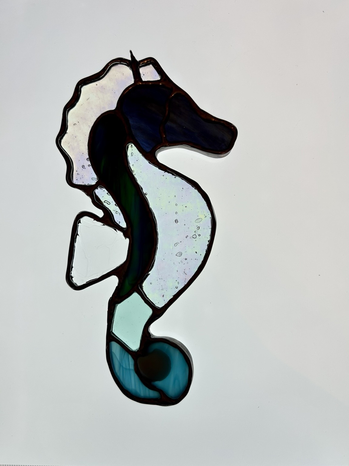 Curving blue and green glass with an iridescent body.