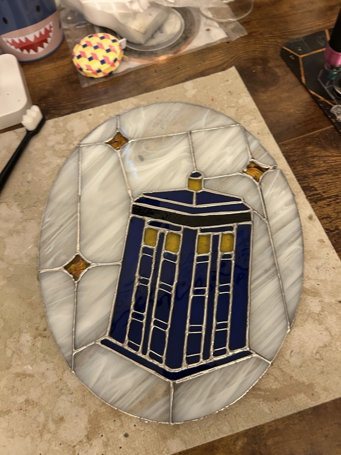 A blue police box surrounded by pearly glass and golden star accents.