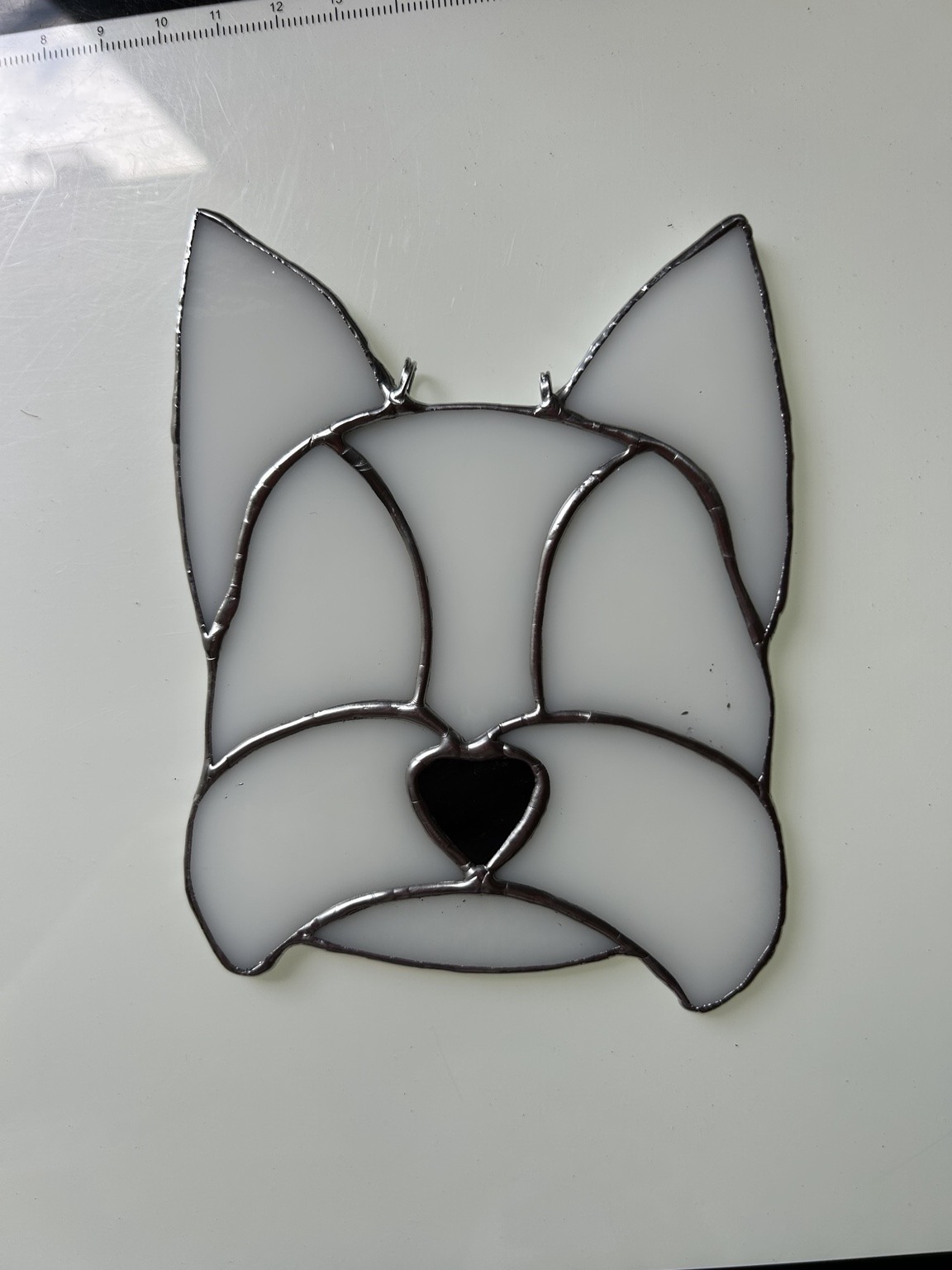 Pale glass and a heart-shaped black nose in a pointed-ear dog design.