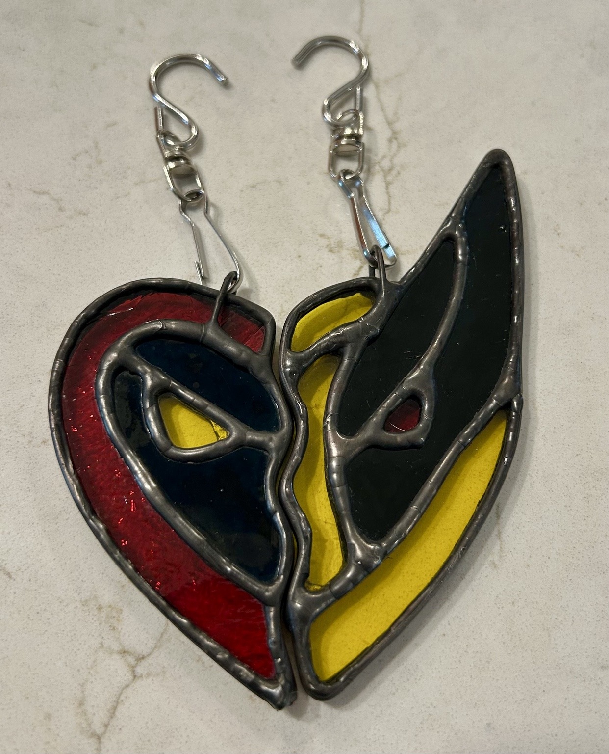 Red and yellow mask-inspired glass pieces that form a heart together.