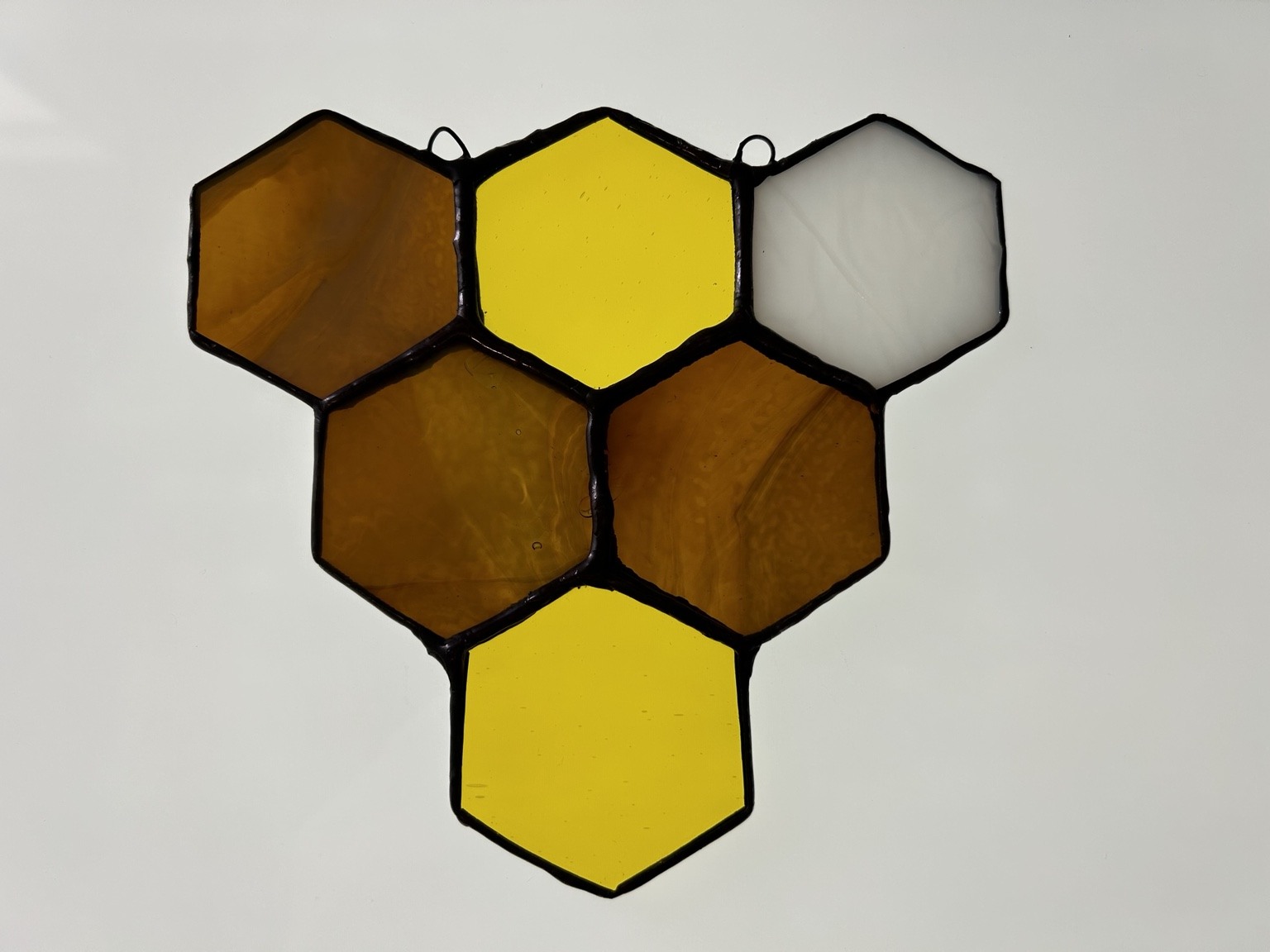Connected hexagons in golden amber, yellow and white glass.