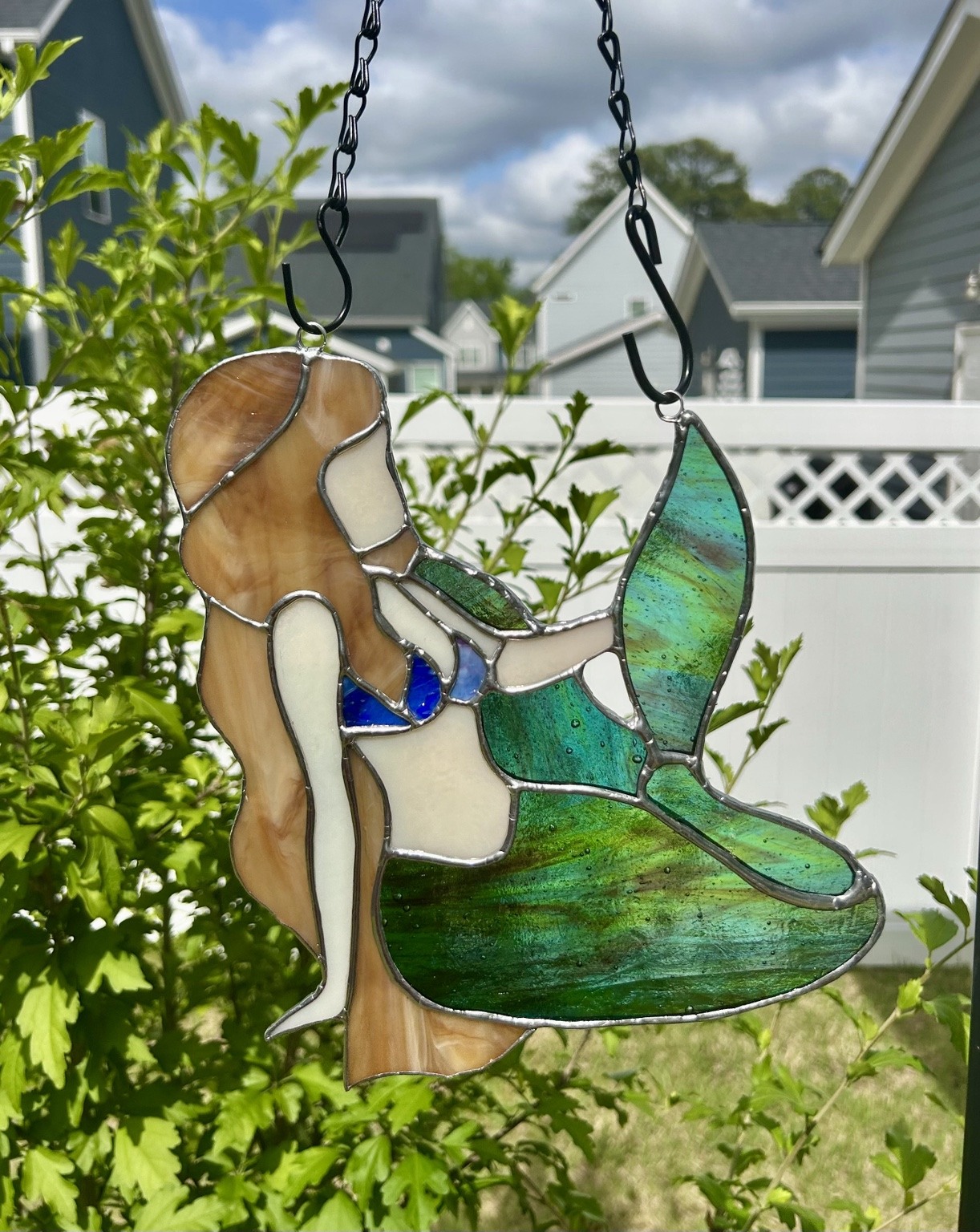 A flowing green tail, golden hair and blue accents in glass.