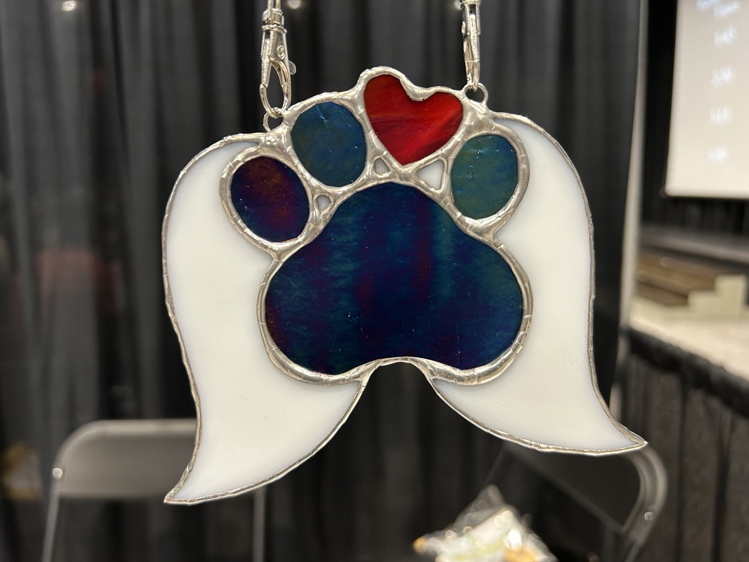 A winged paw design in deep blue, white and red glass.