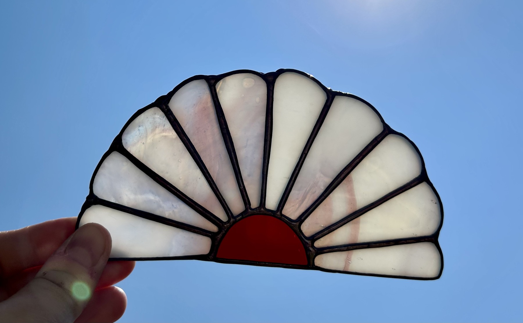 Soft pearly glass radiating from a warm coral center.