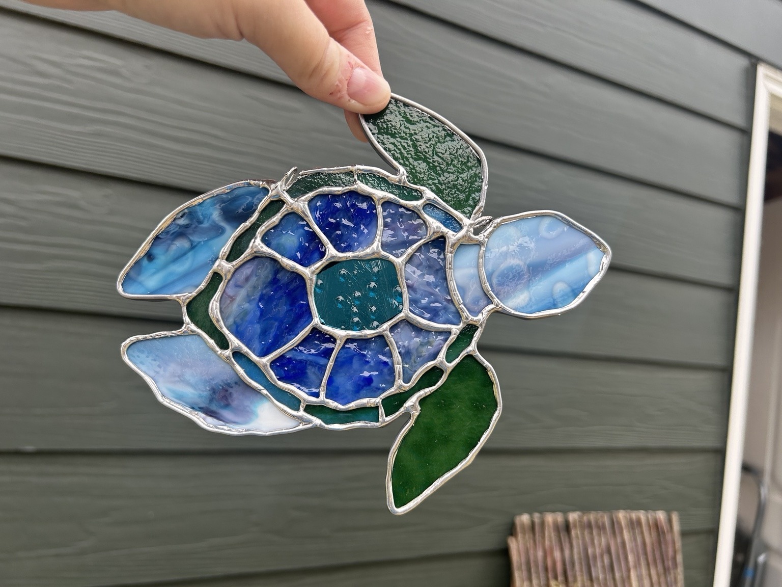 Blue and green glass arranged in a patterned turtle shell and flowing flippers.